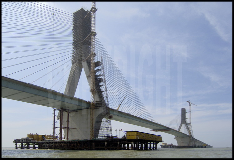 June 2005. Last foundation and binding works on main suspended bridge (roadway height : 40 m), where biggest vessels can get through from Hangzhou bay to Eastern China Sea. Bridge towers are 159 m high for a 420 m width.