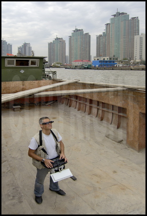 All aerial shots of this story where made from the sea or the river-like from this barge, cruising in Huang Pu river- with a remote-controlled ballon. On background, habitation towers of new city of Pudong (meanings 