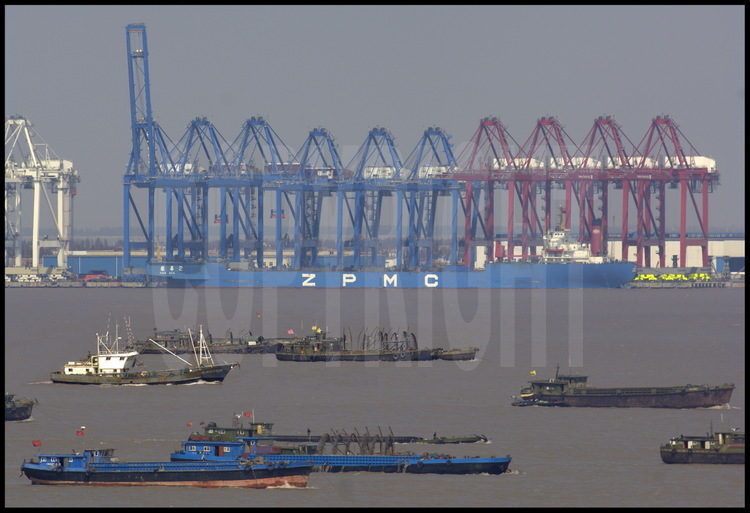Situated on south rim of Changxing Dao island (close to Zhenhua village), the ZMPC (Zhenhua Port Machine Company) port equipment plant was exporting about 1500 cranes to 70 harbours from 37 countries in 2005, representing almost 60 percent of the whole world market. On foreground, south arm of the Yang Tse Kiang estruary, with its amazing trafic of any kind of boat ( fishing, military, bulk carrier, etc.).