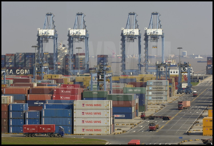 Terminal 4 du port de Waigaoqiao, qui accueillent les plus grandes compagnies mondiales –à l’exception des chinoises, qui sont restées dans les terminaux plus anciens-.Prévu initialement pour un trafic annuel de 1,8 million de containers, il a déjà atteint 3.8 millions fin 2005, ce qui correspond à lui seul au trafic annuel d’un très grand port européen. En arrière plan, le bras sud de l’embouchure du Yang Tse Kiang.