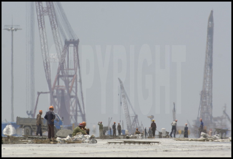 June 2005. Men at work on the 720000 meter square concrete slab -supported by 2819 piles- of Yangshan deep water harbour first phase of the work.