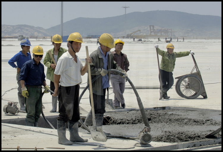 June 2005. Men at work on the 720000 meter square concrete slab -supported by 2819 piles- of Yangshan deep water harbour first phase of the work.