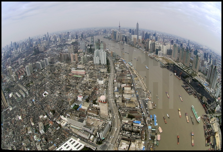 Downtown Shanghai from top of Huang Pu river, with its huge trafic of vessels and barges of any tonnage. On left, historic center of Shanghai, with its two floors houses builded at the end of XIXth century. On right, Yang Jia Du harbour installations -dedicated to raw matérial- to be destroyed soon. On left background, center of Puxi (meanings 