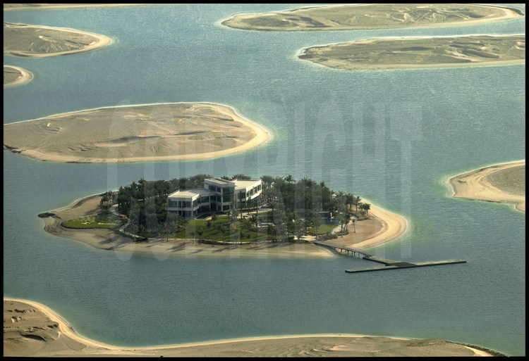 June 2006. Located 4 km from the coast, this enormous off-shore site is a group of 300 small artificial islands laid out to represent our planet’s continents and main islands.  Each island will cover 2 to 8 hectares and will be 50 to 100 meters from its neighbor.  Surrounded by an oval dyke, the archipelago will span a width of 8 km and a length of 6km.  The embankment work should be finished at the end of 2006.  The sample island and its villa are surrounded by North America and Greenland.  Below, North America and the ridge of the Andes mountain range face Africa.  Asia is coming along nicely but Europe, South East Asia and Oceania have barely emerged.  The “France” island will have a surface area of 4 hectares.  The “Australia” island has already been sold to a Kuwaiti real estate company.  The “Spain” island has already been sold to Spanish brand name “Zara” owner.  Each island is sold between 7.5 and 36 million dollars depending on its surface.  The entire project has cost nearly 2 billion dollars.