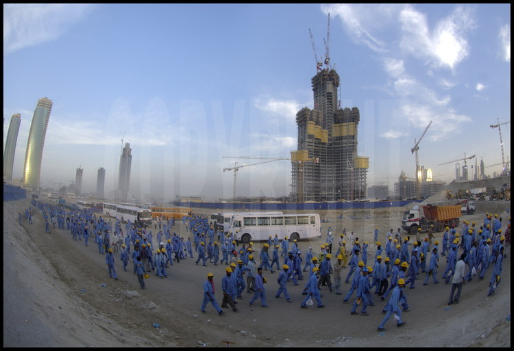 About 5000 construction workers mostly from India and Pakistan work daily on the Burj Dubai Tower complex construction site as well as on neighboring sites (mall, etc).  
They are paid about 1 dollar per hour rand are on site starting at dawn, working twelve-hour days.  The workers are housed and fed in “work camps” in the desert, half an hour’s bus ride from the city and send nearly all of their salaries to their families back home.