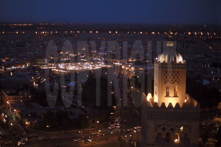 Vus de nuit, le minaret de la Koutoubia et la place Jemaa el Fna (en arrière plan)