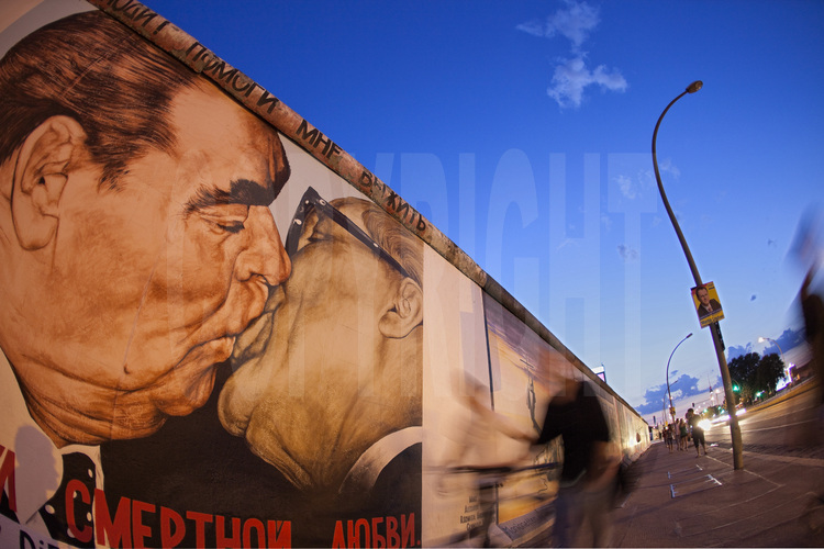 The East Side Gallery. Located on the Mühlenstrasse in the Friedrichshain district is the largest segment of wall preserved. 1300 meters long and historic monument in 1992, it has also become the largest open air gallery in the world. Before 1989, the wall was white and gray, a barrier prevented from approaching or touching. The entire river, which acted as a 