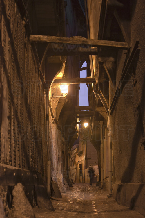Dans le centre historique, la ruelle des Chats à la tombée du jour, vue depuis le carrefour avec la rue Champeaux.