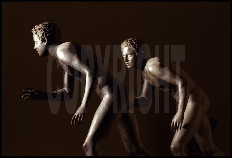 Herculanum, villa des papyrus. Ces deux statues jumelles en bronze, qui représentent deux jeunes gens prêts à la course, sont considérées comme des répliques d'un modèle grec qui pourrait avoir été un athlète des Jeux Olympiques. On notera le soin apporté au rendu des cheveux et des yeux.