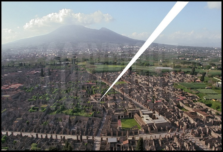 Aerial view of Pompeii’s center with arrow on the Viccolo Storto Brothel.  In the foreground on the right, the intersection of the ancient city’s two main arteries, Via del Vesuvio and via dell’Abondanza, home to the Stabies baths.  In the background, Mt Vesuvius.