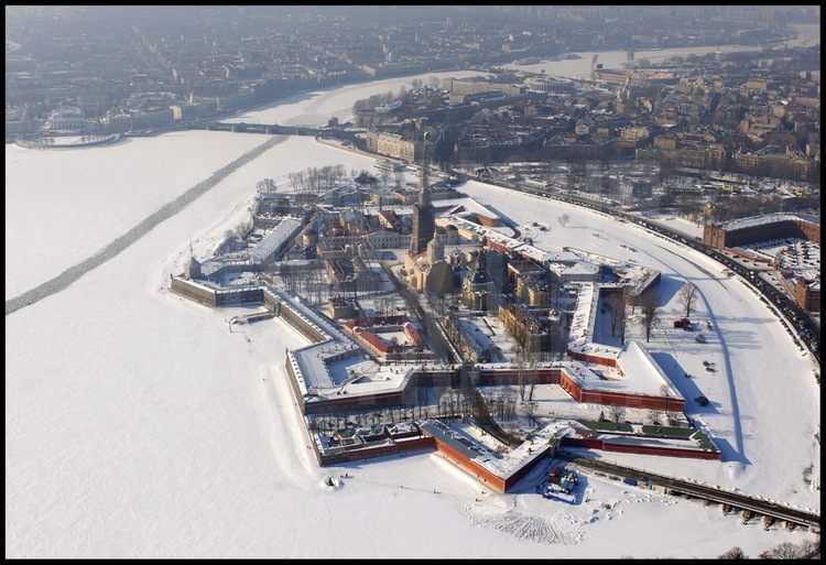 Aerial view of the Peter and Paul Fortress.  Its construction in 1703, 
decided on by Peter the Great, is St Petersburg's birth certificate.  The 
first wooden citadel was replaced with stone according to Italian architect 
Domenico Trezzini's plans.  At the center of the fortress, the Saint Peter 
and Saint Paul Cathedral.  In the background from left to right:  the Strelka 
(the tip) of Vassilievski Island with the Marine Museum and the Rostral 
Columns, Petrograd, the city's first neighborhood also founded in 1703.