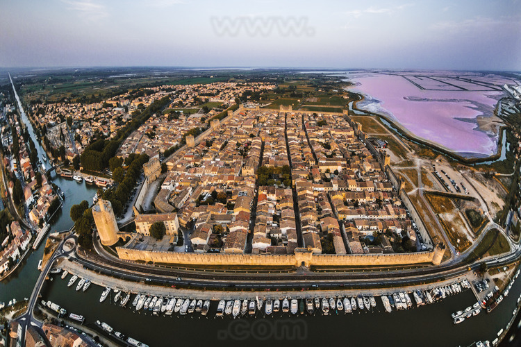 The walled city from the west. On the left, the tower of Constance. In the background on the right, the Salins du Midi (purplish in summer).