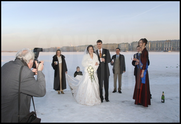In front of the Strelka (the tip) of Vassilievski Island, St Petersburg's 
young married couples celebrate their union on the frozen Neva.  In the 
background, the Palace banks with, on the right, the Hermitage and the Winter 
Palace.