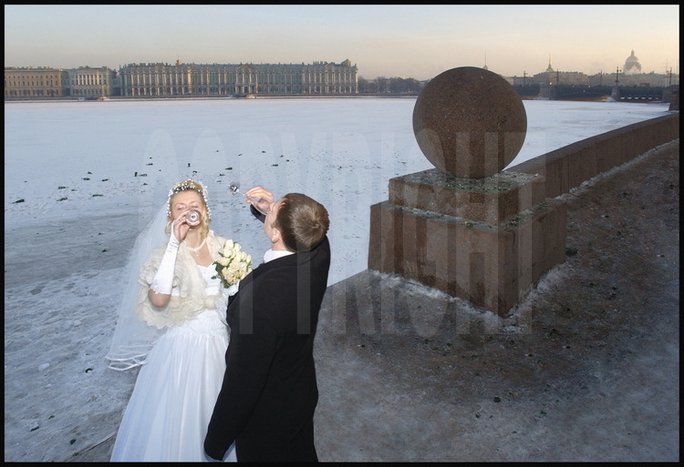 In front of the Strelka (the tip) of Vassilievski Island, St Petersburg's 
young married couples celebrate their union on the frozen Neva.  In the 
background, the Palace banks with, from left to right, the Hermitage and the 
Winter Palace, the Admiralty, Saint Isaac's Cathedral.