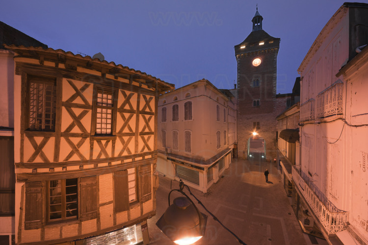 Villeneuve sur Lot : Paris street and the tower of Paris at dusk. On the left, a medieval half-timbered house.