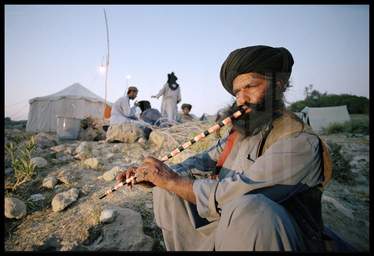 Campement de l’expédition, près du site de Lundo. Au crépuscule, Kehar, le chef des gardes Bugtis de l’expédition qui est aussi chanteur et musicien de musique traditionnelle.