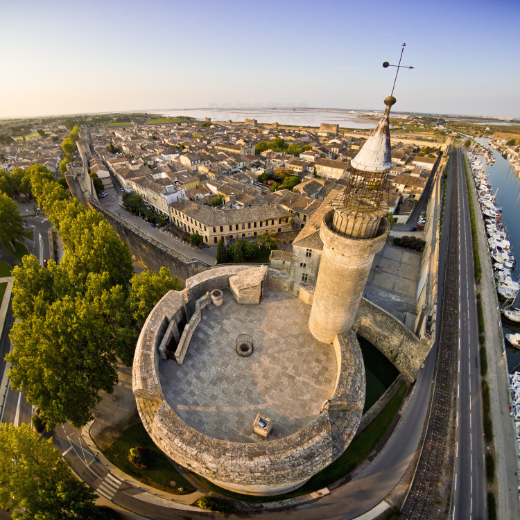 Top of the tower of Constance seen from the north. In the background, the walled city and the Salins du Midi (purplish in summer).