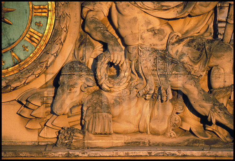 Éléments sculptés ornant la grande horloge du Château, réalisé par Marsy en 1679, d’après un dessin de Le Brun. Il représente Mars au repos accompagné d’un bélier qui symbolise la victoire de la France sur ses ennemis.