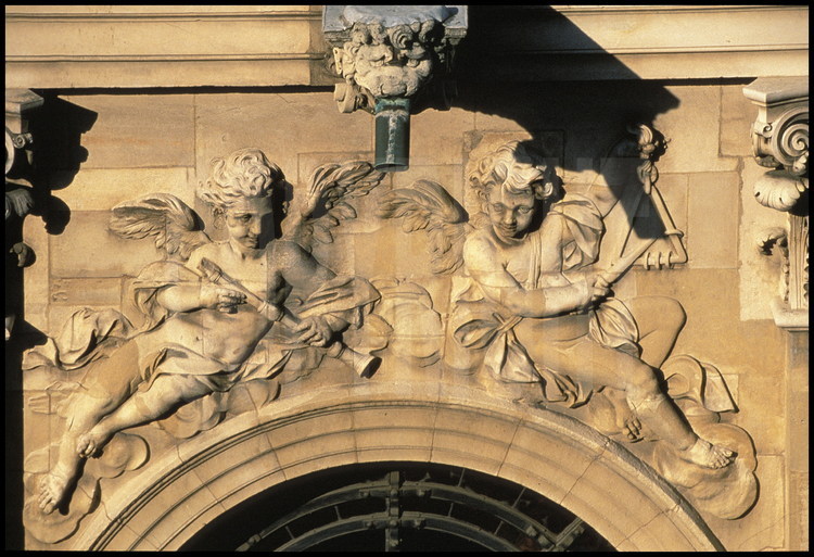 Sur la façade sud de la Chapelle, détail du décor sculpté sur les croisés de la tribune : anges jouant de la flûte et du triangle.