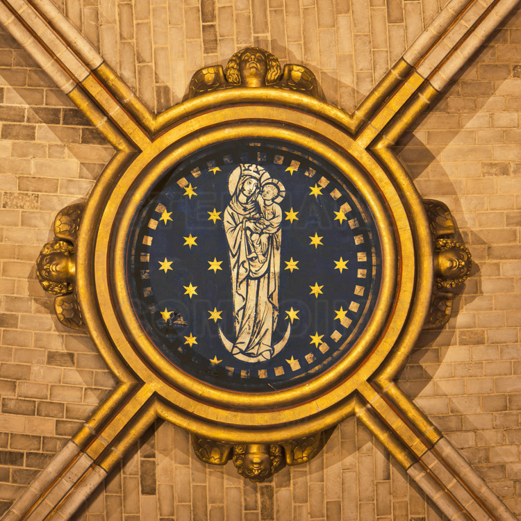 At the transept crossing, the central keystone to the transept crossing, decorated with the Virgin with the Crescent, Moon symbolizing the world.