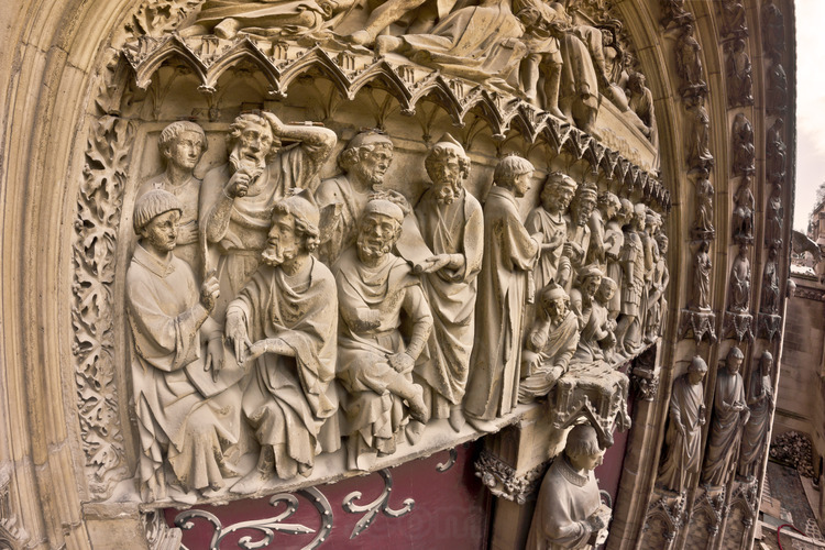 South facade, portal of Saint Etienne. The tympanum narrates the life of Stephen, which was dedicated to the first cathedral of the diocese of Paris, before the construction of Notre Dame. In this detail, Étienne was denounced as a blasphemer and taken to court. Altitude 8 meters.