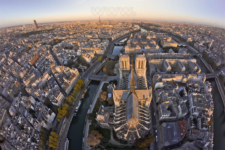 Notre Dame and its chevet seen from the east. The cathedral looks like wrapped in its side chapels and flying buttresses. Only growth, in the south side: the sacristy and treasury rooms. In the foreground (l. to r.), the Latin Quarter, the Quai Montebello, the southern arm of the Seine, the street of Cloitre Notre Dame, the  School of Magistracy and the north arm of the Seine. In the second ground, the square René Viviani, the Pont au Double, the Prefecture of Police, the Hôtel-Dieu, the Palais de Justice and Place du Chatelet. In the background (from l. to r.), the Montparnasse Tower and the Eiffel Tower. Altitude 115 meters.