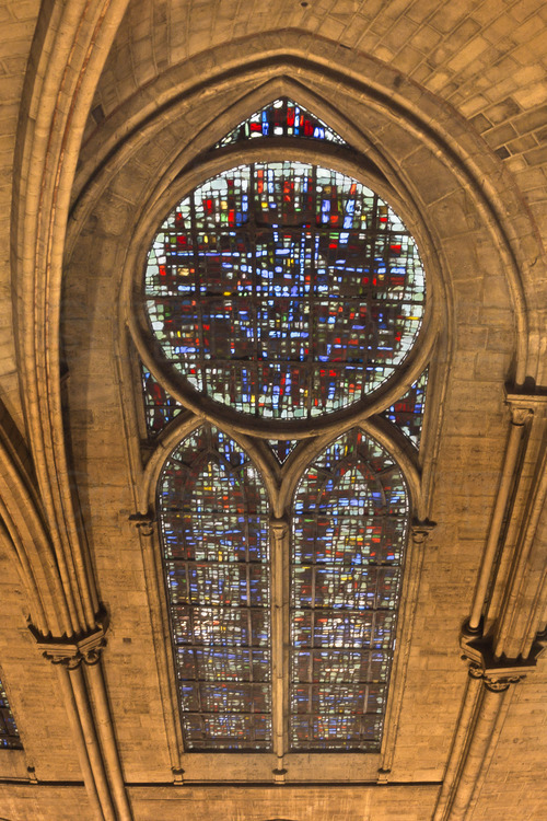 In the nave, the upper windows of the first six bays are decorated with non-figurative windows, created by Jacques Le Chevalier in the late 1960s. Glass mosaics incorporate the colors of large roses from the Middel Ages. The artist is also the author of the eighteen windows of tribunes.