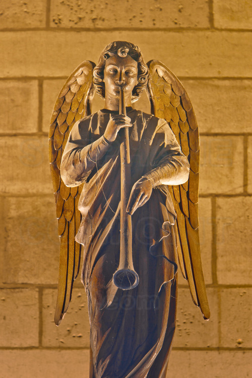 Overlooking the interior doors of the portal of the Last Judgment, a wood carving of an angel musician. This portal is only open on great occasions.