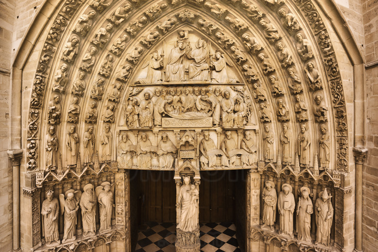 At the height of the portals of the west facade. North of the western façade overview of the Portal of the Virgin, which has served as a model for image-makers throughout the Middle Ages. The central tympanum represents the coronation of Mary : Christ sets a scepter to his mother, who is crowned by an angel. At the central lintel, the Dormition of the Virgin, in the presence of Christ and the apostles. At the the lower lintel, the Ark is surrounded by prophets who announced the glorious destiny of the Mother of God, Mary and the kings that she's the descendant. Around the central tympanum, the arches are lined with leaves, flowers and fruits. Four cords evoke the heavenly court, with angels, patriarchs, kings and prophets. Altitude 11 meters.