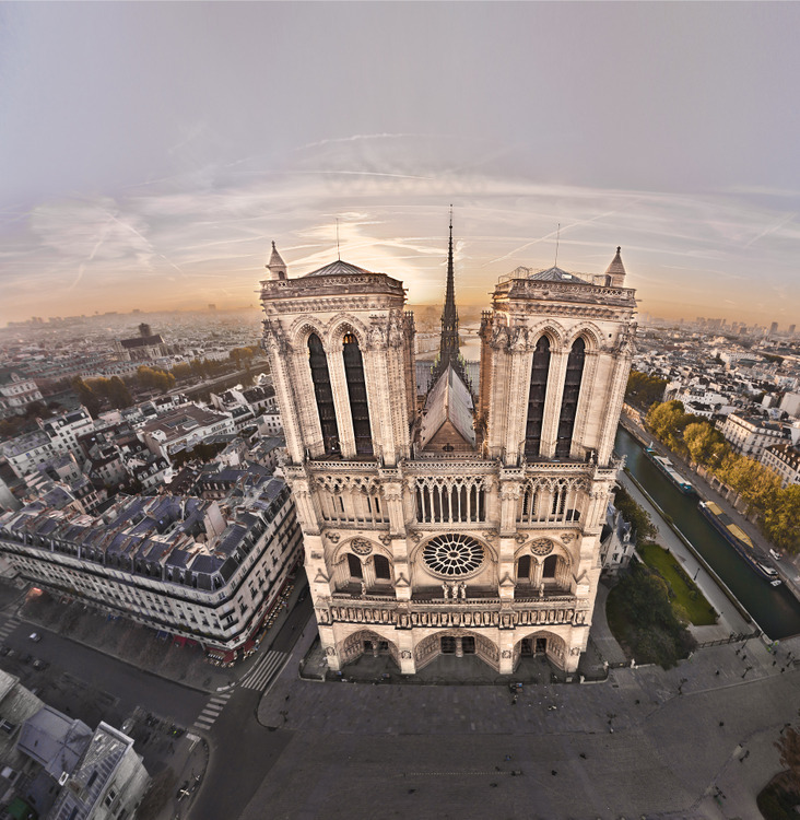 The west facade of Notre Dame at sunrise, Ile de la Cité. On the court, the zero kilometer point, which marks the intersection of the roads of France. In the center, the arrow (rebuilt in the nineteenth century on the foundations of the old, shot in the Revolution) is 96 meters and towers 69 meters. Narrow and very high bays (over 16 meters) give them lightness. The façade is 43.5 meters wide. At the forefront of g. to d., Arcola street, the square of Notre Dame, the South arm of the Seine and Quai de Montebello. In the background l. to r., the church of Saint Gervais and the Latin Quarter. Altitude 60 meters.