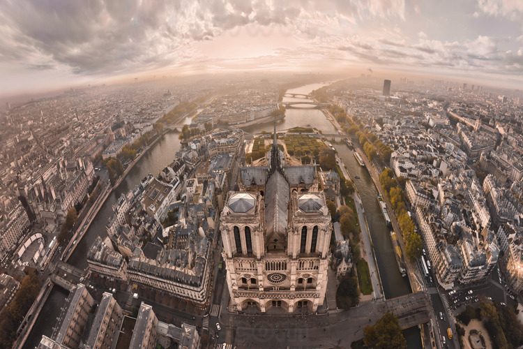The west facade of Notre Dame de Paris at sunrise. On the court, the zero kilometer point, which marks the intersection of the roads of France. In the foreground, l. to r., the place de l'Hotel de Ville, the north arm of the Seine and the bridge of Arcola, Arcola Street, the square of Notre Dame, the southern arm of the Seine and the Pont au Double, the Lagrange street and the Square René Viviani. In the second ground, l. to r., City Hall, the National School of the Judiciary, Square Jean XXIII, the bridge of the Archdiocese, the Quai de Montebello and the Latin Quarter. In the background of l. to r., the Quai de l'Hotel de Ville, the church of Saint Gervais, Saint Louis island, the bridges of Tournelle and Sully, the Jussieu university and École Polytechnique. Altitude 140 meters.