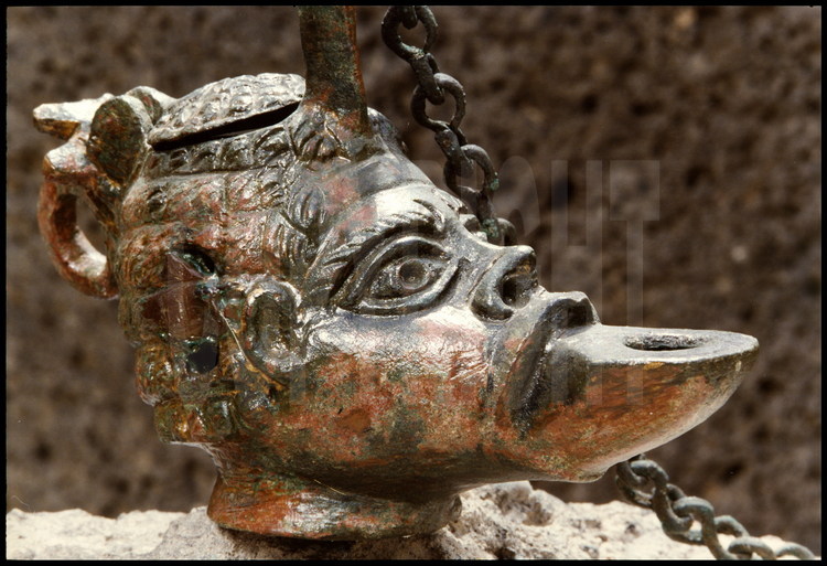 Retrouvée durant les fouilles de la grande villa romaine, cette lampe à huile en bronze représente en tête de roi Nubien.
