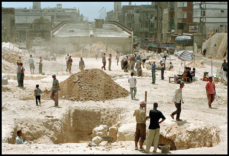 General view of the Necropolis digging site.  In the background, the overpass whose construction led to the ancient site’s discovery.  Today, the overpass threatens its preservation.  For the duration of the digs, two hundred workers are on site daily with the archeologists.