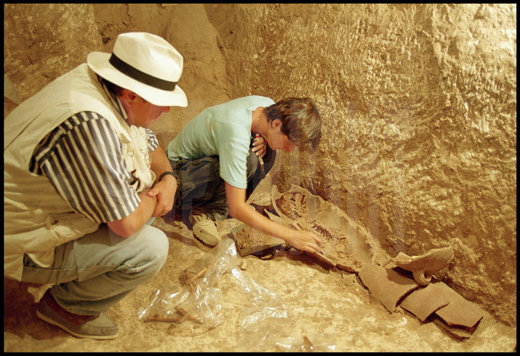 Les archéologues Jean-Yves Empereur (à gauche) et Hélène Silhouette (à droite) dégagent de la tombe II un squelette d'enfant en parfaite 