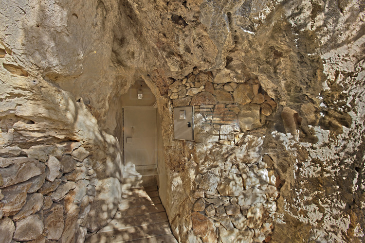 Dans la Combe d'Arc, à flanc de falaise, l'entrée de la grotte Chauvet originelle. Datée de 36000 ans, la grotte Chauvet fut découverte en décembre 1994 et immédiatement fermée au public en raison de son immense intérêt scientifique et à une forte présence de dioxide de carbone. Sur ses parois, les œuvres des premiers artistes de l'Histoire.