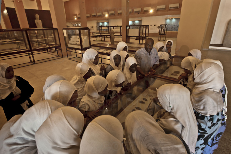 A class of young Sudanese students visit the National Museum in Khartoum with their teacher.