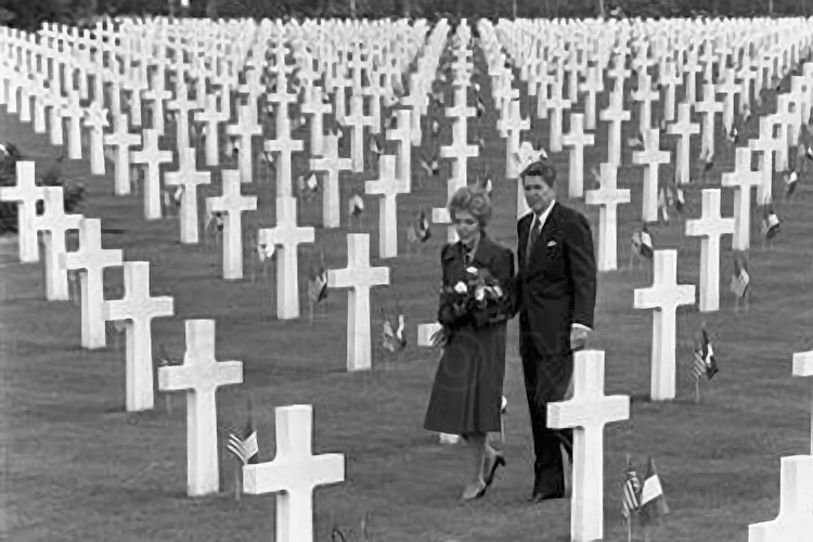 Normandie - Calvados (14) - Colleville sur Mer : Site 3 : Cimetiere americain de Colleville sur Mer. Inaugure officiellement en 1956, cette necropole de 70 hectares est installee sur les hauteurs qui surplombent la plage d'Omaha Beach. Il a ete concu par Harbeson, Hough, Livingston & Larson et l'espace a ete arrange par l'architecte paysagiste Markley Stevenson qui a fait en sorte que, de n'importe quel angle, on voit une rangee de croix. A l'entree du cimetiere, une statue en bronze de 7 metres de haut, a l'interieur du demi-cercle forme par la colonnade du memorial, fait face aux carres des tombes. Elle symbolise l'Esprit de la jeunesse americaine s'elevant des flots. Cette statue est entouree de galets symbolisant la difficulte des tanks a passer la plage. Les steles de marbre blanc sont en forme de croix latine ou en forme d'etoile de David pour les soldats de confession juive. Dans le cimetiere sont enterres les corps de 9 388 personnes, dont 307 inconnus et quatre femmes. Ces personnes sont principalement decedees le jour du debarquement ou dans les semaines suivantes en Normandie, principalement au combat. 14 000 depouilles, d'abord inhumees en Normandie, ont ete rapatriees aux Etats-Unis, a la demande de leurs proches. 3 titulaires de la Medal of Honor morts en Normandie reposent a Colleville, dont le general Theodore Roosevelt Junior (1887-12 juillet 1944, fils aine du president des Etats-Unis Theodore Roosevelt et lointain cousin du president Franklin Roosevelt). Deux des freres Niland, dont l'histoire a inspire Steven Spielberg pour ecrire le scenario du film 