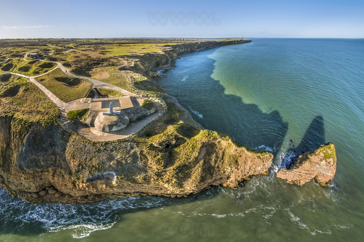 Normandie - Calvados (14) - Cricqueville en Bessin : Site 2 : Pointe du Hoc. La pointe du Hoc surplombe une falaise de 25 a 30 metres de haut avec une plage de galets d'une dizaine de metres de large a ses pieds. Situee entre les plages de Utah Beach (a l'ouest) et Omaha Beach (a l'est), la pointe avait ete fortifiee par les Allemands et, selon les reconnaissances aeriennes alliees, etait equipee de pieces d'artillerie lourde dont la portee menacait les deux plages voisines. Il avait ete juge primordial, pour la reussite du debarquement, que les pieces d'artillerie soient mises hors service le plus rapidement possible. Cette mission fut confiee au 2e bataillon de Rangers americain qui reussit a prendre le controle du site au prix de lourdes pertes. Sur les 225 Rangers qui debarquerent ce jour-la, 135 (en date du 8 juin 1944, en comptant les hommes du LCA 860) furent tues. Le lieutenant-colonel James Earl Rudder lui-meme fut blesse par deux fois durant cette operation. En janvier 1979, la France a legue une partie des terrains de la pointe du Hoc aux Etats-Unis. // France - Normandy - Calvados (14) - Cricqueville en Bessin: Site 2: Pointe du Hoc. The Pointe du Hoc overlooks a 25 to 30-metre-high cliff with a ten-metre-wide pebble beach at its foot. Situated between Utah Beach (to the west) and Omaha Beach (to the east), the Pointe had been fortified by the Germans and, according to allied aerial reconnaissance, was equipped with heavy artillery whose range threatened both nearby beaches. It was deemed vital to the success of the landings that the artillery pieces be put out of action as quickly as possible. This mission was entrusted to the 2nd American Ranger Battalion, which succeeded in taking control of the site at the cost of heavy losses. Of the 225 Rangers who landed that day, 135 (as of June 8, 1944, including the men of LCA 860) were killed. Lieutenant-Colonel James Earl Rudder himself was wounded twice during the operation. In January 1979, France bequeathe