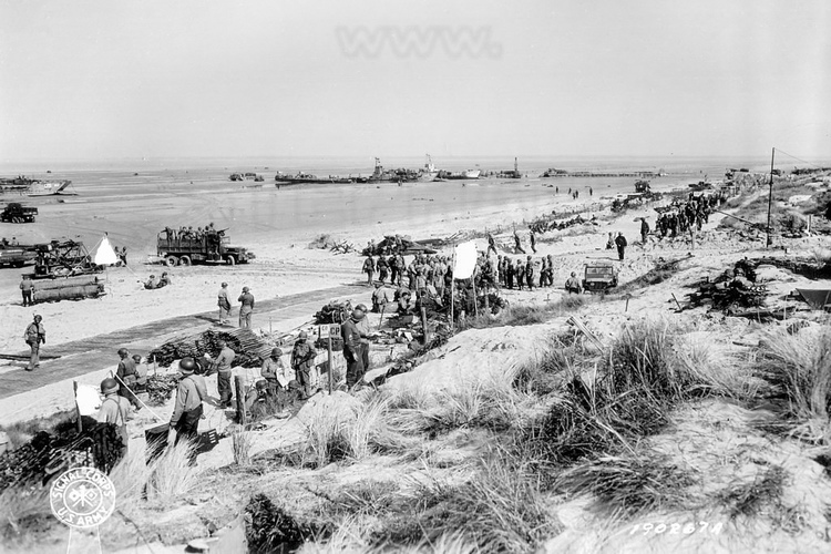 Normandie - Manche (50) - Sainte Marie du Mont : Site 7 : Utah Beach - La Madeleine - Borne n 00 de la Voie de la Liberte. La Voie de la Liberte est une voie de 1 142 kilometres qui commemore la victoire des Allies et la liberation de la France, de la Belgique et du Luxembourg pendant la Seconde Guerre mondiale. Elle est materialisee par une serie de bornes kilometriques le long du reseau routier entre Utah Beach (et Sainte-Mere-Eglise pour la borne 0) et Bastogne dans la province belge du Luxembourg, marquant l'itineraire suivi par la 3e armee americaine commandee par le general Patton. Le 6 juin 1944, en Normandie, les Forces americaines debarquent sur Utah Beach, a 2,5 kilometres plus au sud que prevu. Cette erreur de navigation est benefique, elle met les troupes americaines hors de portee des puissantes batteries cotieres de Crisbecq-Saint-Marcouf et Azeville. Le Brigadier General Theodore Roosevelt, commandant en second de la 4th US Infantry Division, touche le sol normand a 6 h 40 avec la premiere vague dassaut, composee d'elements du 8th Infantry Regiment et des chars du 70th Tank Battalion. En une heure le genie degage les plages. Les points forts allemands, dont le WN 5 qui defend la plage de La Madeleine, sont neutralises les uns apres les autres. Les Americains avancent vers l'interieur, et en fin de matinee, la jonction est etablie avec les parachutistes de la 101st US Airborne Division. Photos d'archives non disponible a la vente sur ce site mais uniquement presente pour situer le contexte historique. // France - Normandy - Manche (50) - Sainte Marie du Mont: Site 7: Utah Beach - La Madeleine - Terminal no. 00 of the Voie de la Liberte. The Freedom Route is a 1,142 kilometer route which commemorates the victory of the Allies and the liberation of France, Belgium and Luxembourg during the Second World War. It is materialized by a series of kilometer markers along the road network between Utah Beach (and Sainte-Mere-Eglise for terminal 0) and Bastogne in