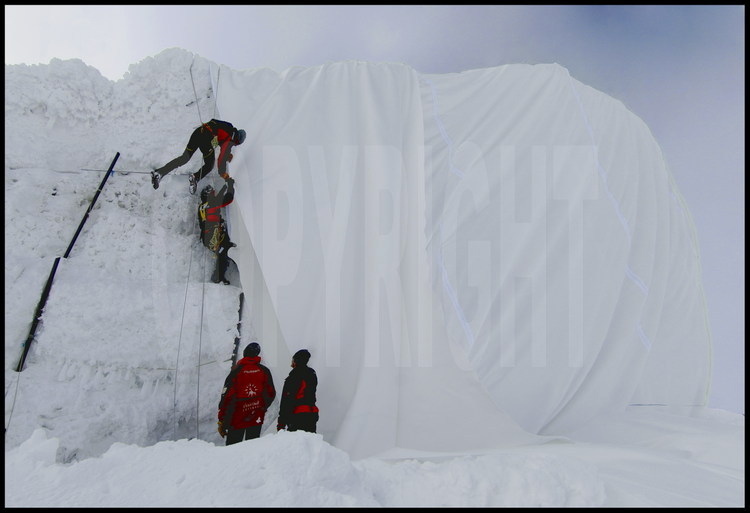 Equiped with high mountain gears, technicians of Andermatt city are climbing along Gemsstock glacier face to fix precisely the different parts of the fabric (each roll is 5 meters large).