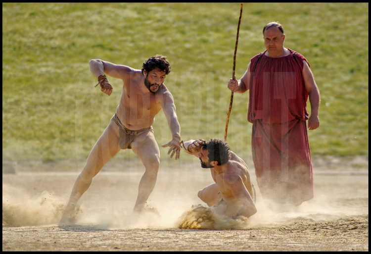 Pierre Dufour (left) and Brice Lopez (right), athletes-researchers in experimental archaeology, compete in the fighting competition under the watch of Greek hellanodice judge-referee Christos Kollias. As this event has no time limit, the combat is over only when one of the fighters gives up.