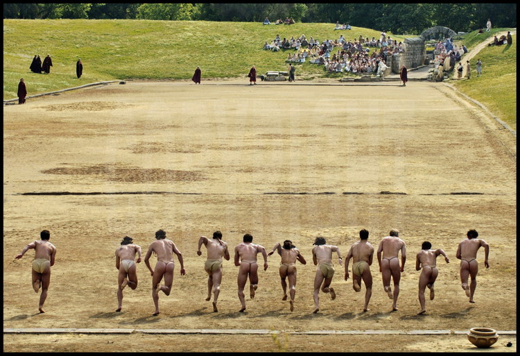 The stadion race (192m) was the most important competition of the ancient games. Beginning the race without a starting block requires specific training for today’s athletes.  As in Antiquity, the athletes spring forward in the direction of Olympia’s sanctuary and the temple of Zeus.