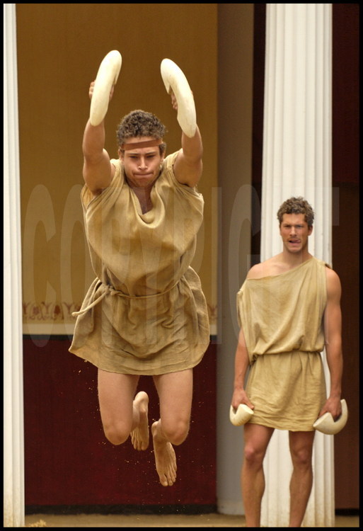 In the palestra’s courtyard, German pentathletes Christophe Maier (left) and Uwe Buchele (right) practice the long jump. During Antiquity, this was made up of five consecutive jumps with barbells and no momentum.