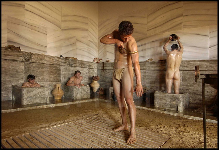 German athletes in the palestra’s baths, rebuilt as in Antiquity.  In the middle, German Christophe Maier uses a scraper called strigile to remove the oil and sand with which athletes lathered their bodies for training and competitions.