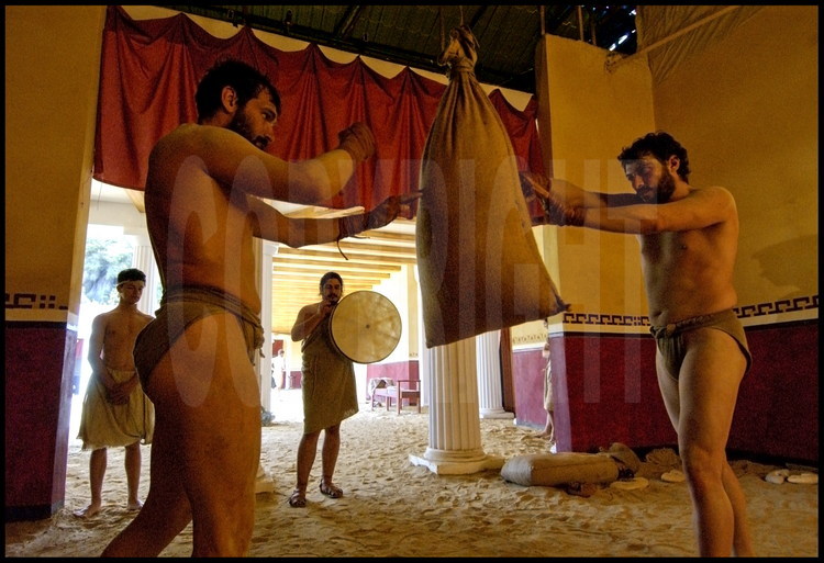 In one of the palestra’s training rooms, athletes in experimental archaeology Brice Lopez (left) and Pierre Dufour (right) practice on a korykos(sand bag) to the sound of the tambourine before a fight competition.