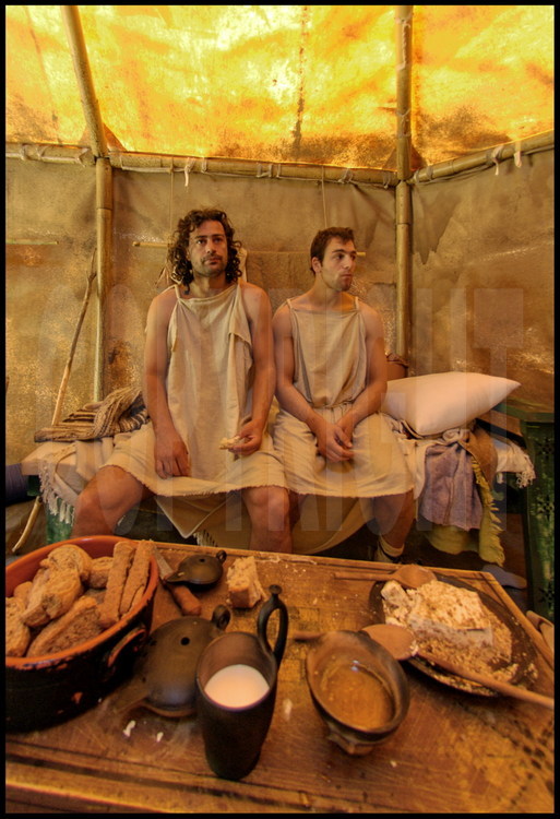 Not far from the palestra, participants stayed in a camp which identically recreated their ancestor’s living conditions.  Inside their tent, Greek athletes have a copious breakfast before their morning training, as their ancestors did.  On the right, Dimitris Plionnis, on the left, Stefanos Tsanoulas.