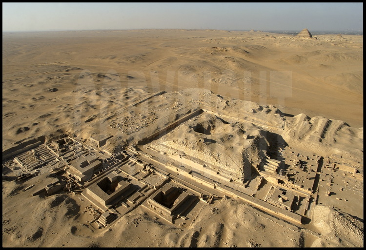 Vue aérienne des vestiges du complexe funéraire et de la pyramide de Pépy 1er (VIème dynastie) depuis le sud est. Au premier plan, le temple funéraire. A gauche, les pyramides des reines. En arrière plan, la pyramide de Djoser (IIIème dynastie).
