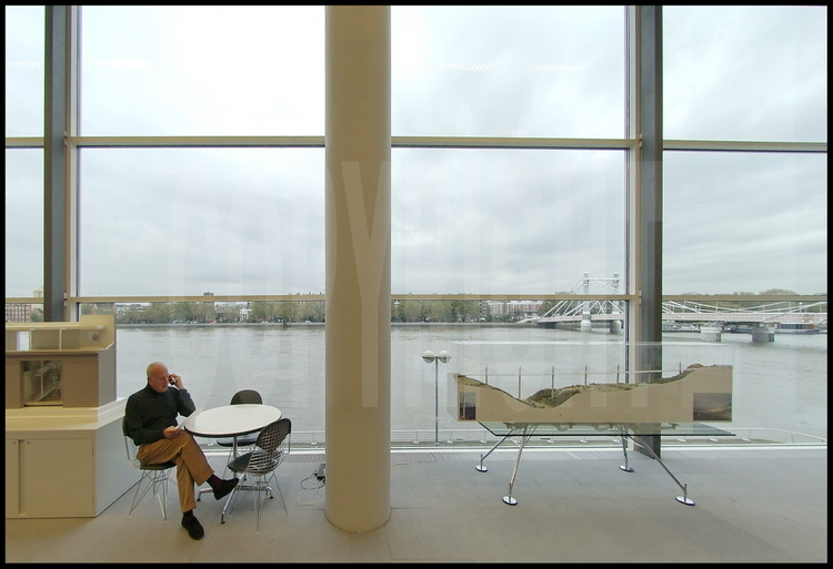 In his offices in the district of Battersea in London, Sir Norman Foster. On the background, the river Thames and the Albert bridge. On the right foreground, the model of the Viaduc de Millau.