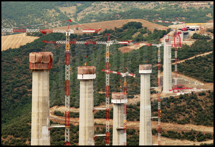 June, 2003.  On this exceptional construction site, the cranes, weighing in at 400 tons, tower at 264 meters setting a new world record.  The concrete piers are built in several lifting installments with the help of a “climbing” compartment which rises at the rate of 4 meters…every three days!  From left to right, piers P5 to P1.  Pier P2, fourth from the left, will measure 243 meters, which will set a world record.