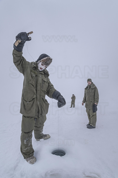 Canada - State of Nunavut - Operation NUNALIVUT 2018 - Surroundings of Cambridge Bay - Survival Camp # 1: Soldiers are initiated by the Rangers into ice fishing, which can save lives in polar isolation.